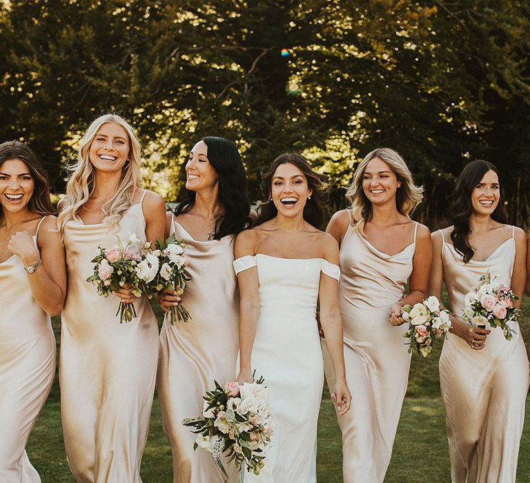  Bridal party in gold cowl neck satin bridesmaid dresses with bride in off the shoulder Halfpenny London wedding dress 