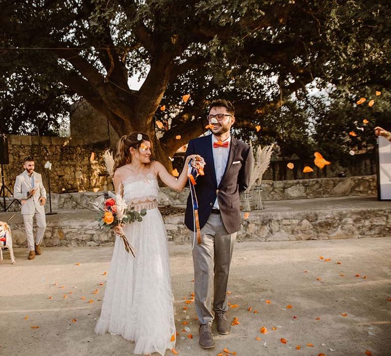 confetti moment at greece destination wedding with boho bride in a lace wedding dress and groom in chinos and blazer