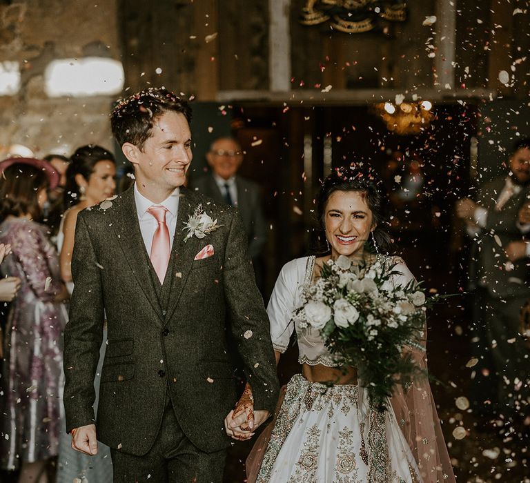 Dried petal confetti moment for bride and groom as they walk out of the ceremony 