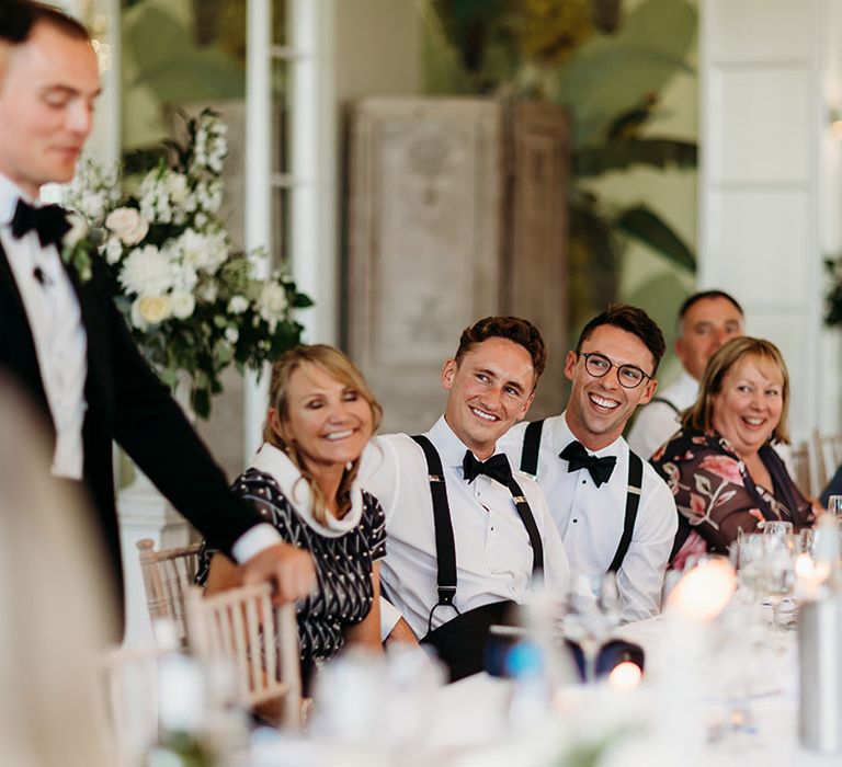 Best men stand to read out wedding speeches at country house wedding 