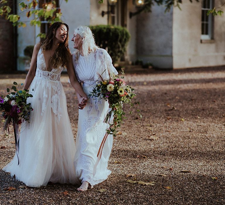 The two stunning brides in boho lace wedding dresses for their LGBTQI+ wedding 