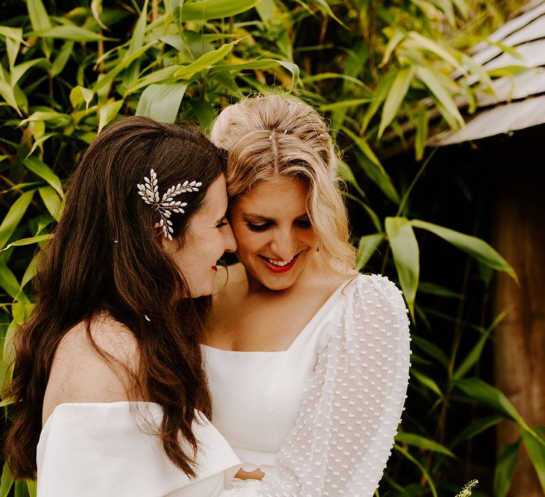 Lesbian wedding with two brides posing for romantic whimsical wedding with wildflower theme 