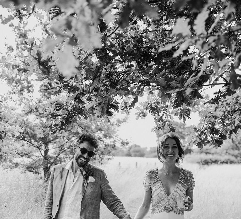 Groom in grey suit with the bride wearing a Jenny Packham wedding dress