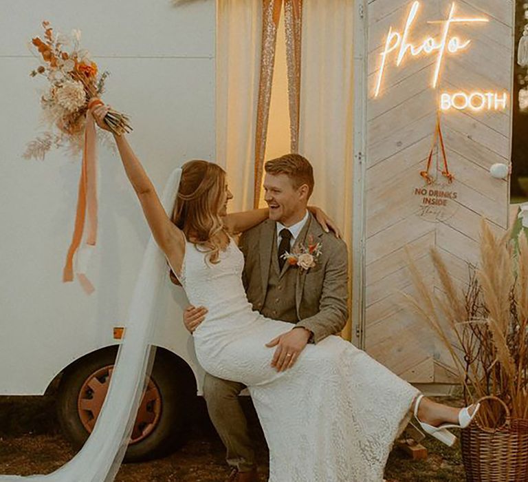 Bride and groom posing outside wedding photo booth