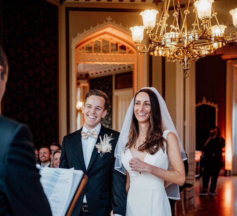 Bride and groom in traditional wedding attire at the luxury wedding venue, Nonsuch Mansion in Cheam 