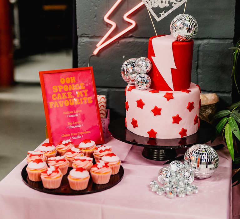 Pink and red wedding cake with lightning and stars decorated with disco ball decorations 