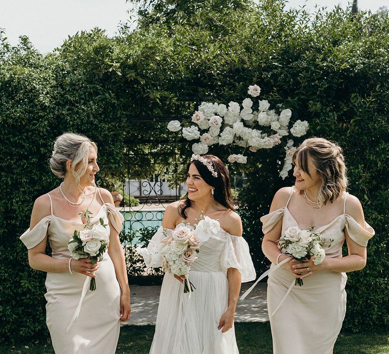 Bridal party wearing champagne coloured satin bridesmaid dresses with neutral wedding bouquets 