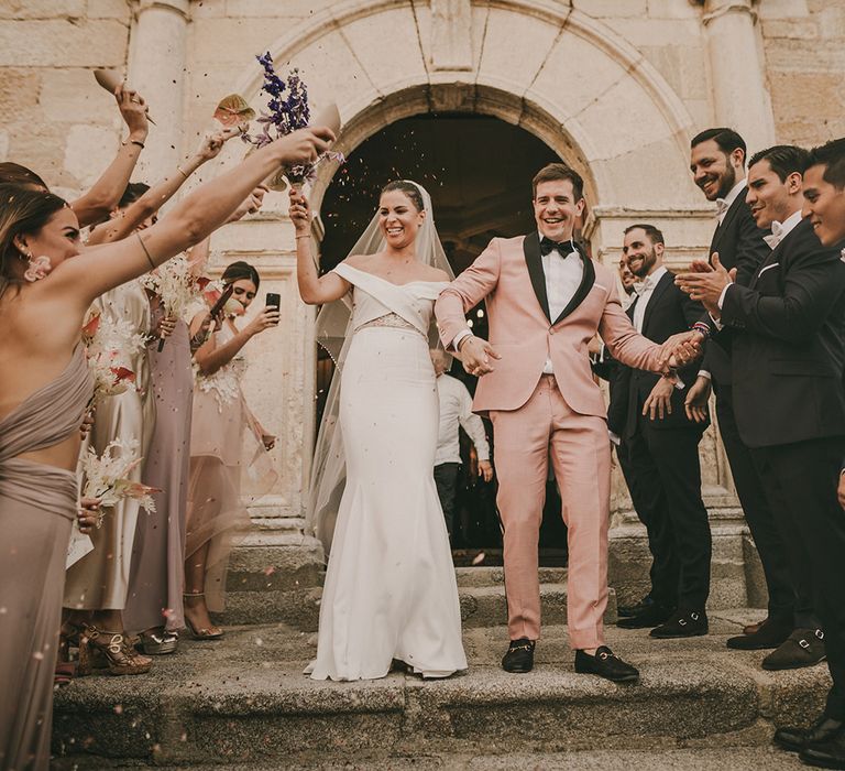 Bride in Rime Arodaky wedding dress and groom in pink tuxedo 