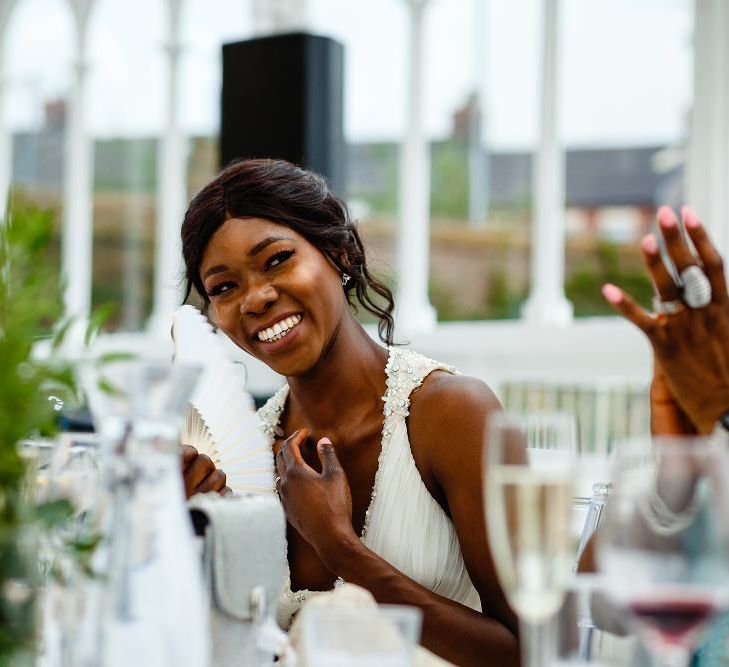 Bride in halter neck wedding dress smiling during the speeches