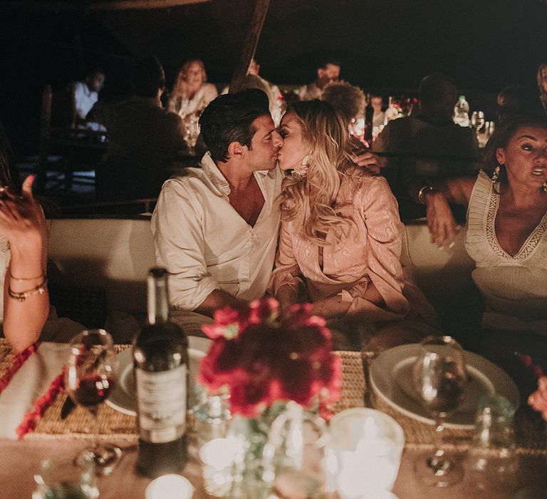 Bride and groom kissing at rehearsal dinner 