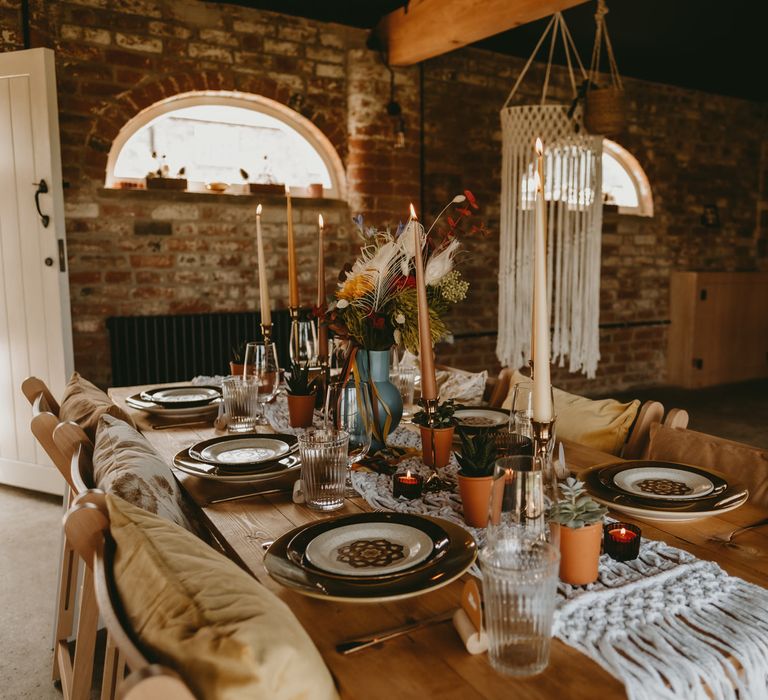 rustic table with macrame table runner, flower centrepieces and candles 