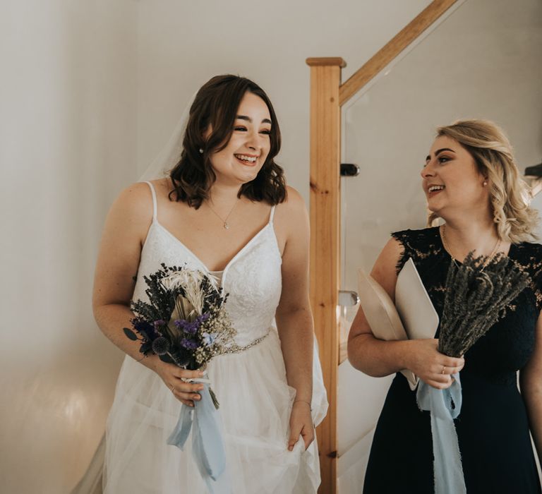 Laughing bride with lavender bouquet and bridesmaid