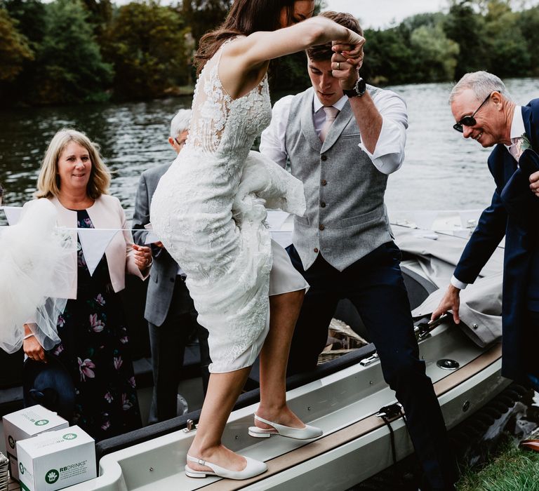 Groom helps bride off boat during wedding reception 