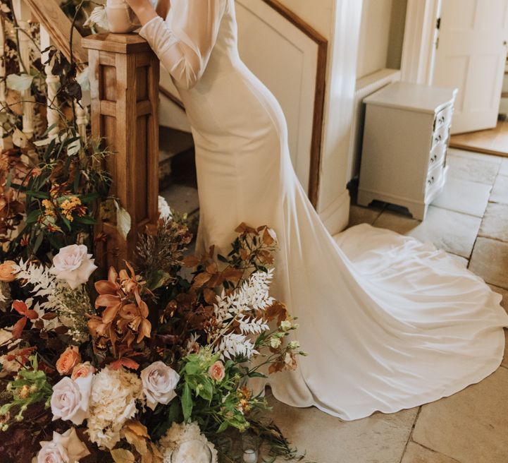 Bride wears sleek long sleeve simple wedding dress at Reymerston Hall