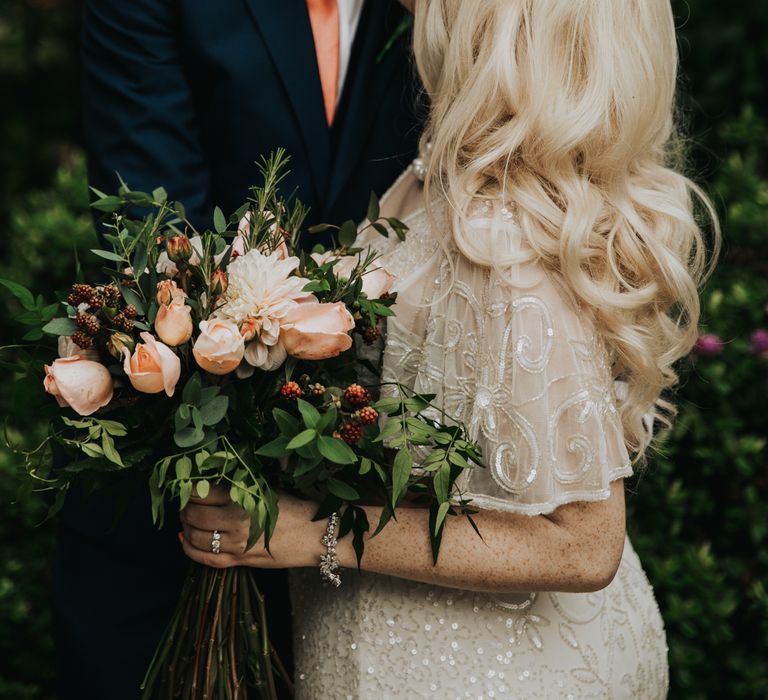 Bride & groom kiss on wedding day with groom in blue suit