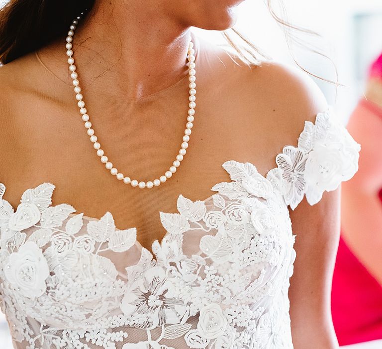 Flower appliqué detail on the brides off the shoulder Galia Lahav wedding dress 