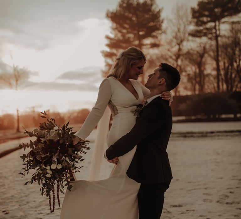 Bride is lifter up by her new husband