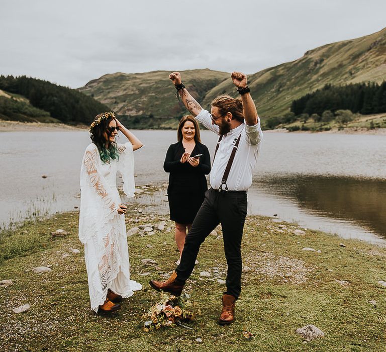 Groom celebrates after marriage in the Lake District