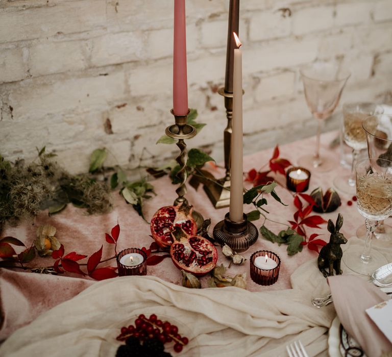 Candlestick and taper candle wedding table decor with votives and figs 