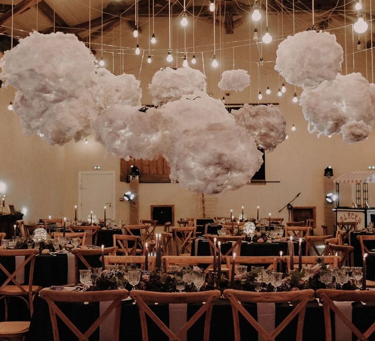 Wedding tables with wooden chairs, purple flower centrepieces and black tablecloths for a starry night theme