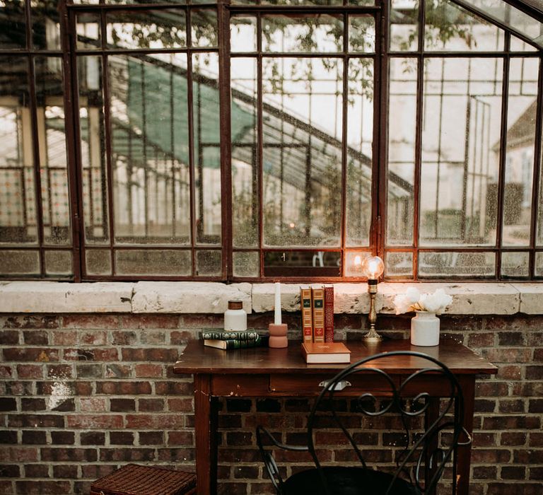 Small desk with wicker baskets, vintage books and candlestick