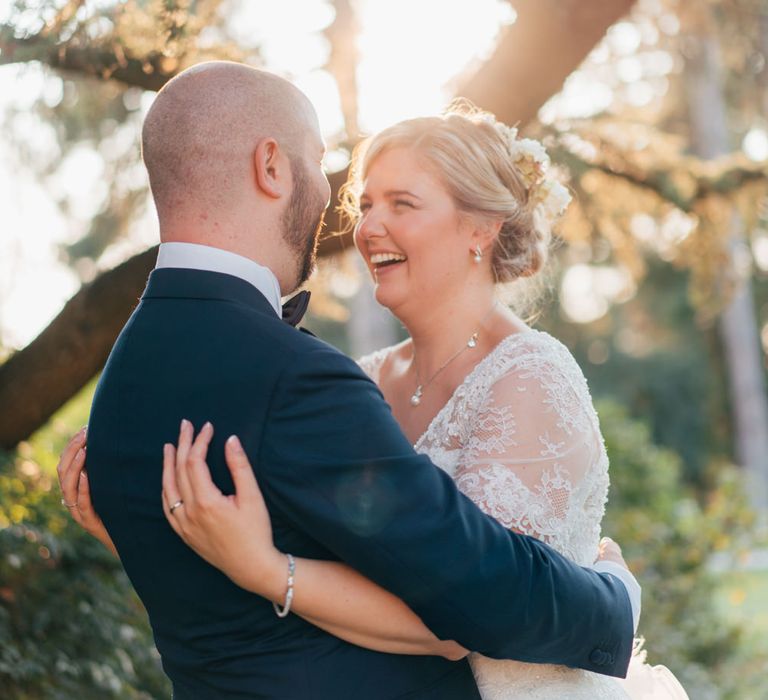 The bride and groom hugging at their red wine themed outdoor wedding ceremony