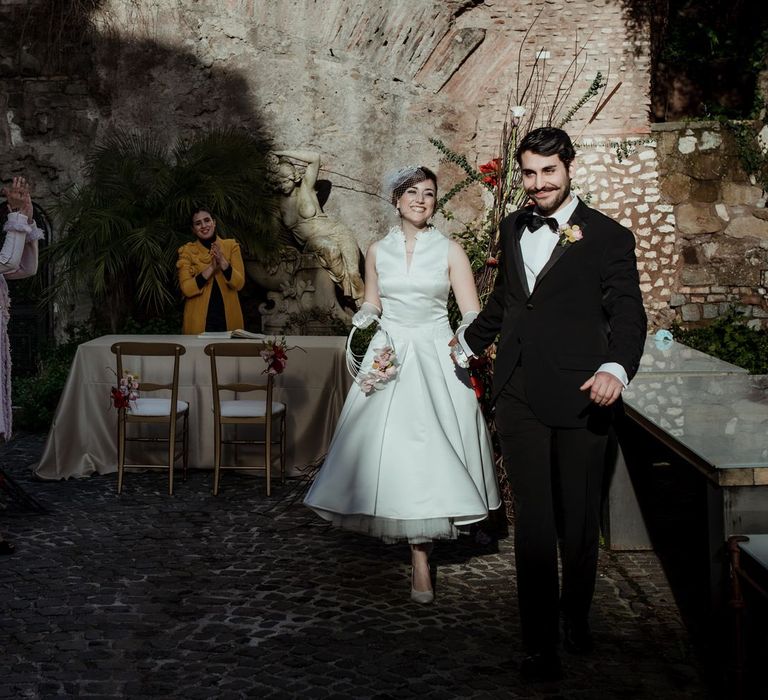 Guests cheering as the bride and groom leave their vintage inspired wedding ceremony in Rome