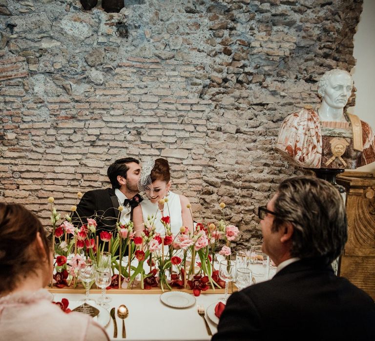 Intimate wedding meal with red and pink flower centrepiece display of tulips and hibiscus