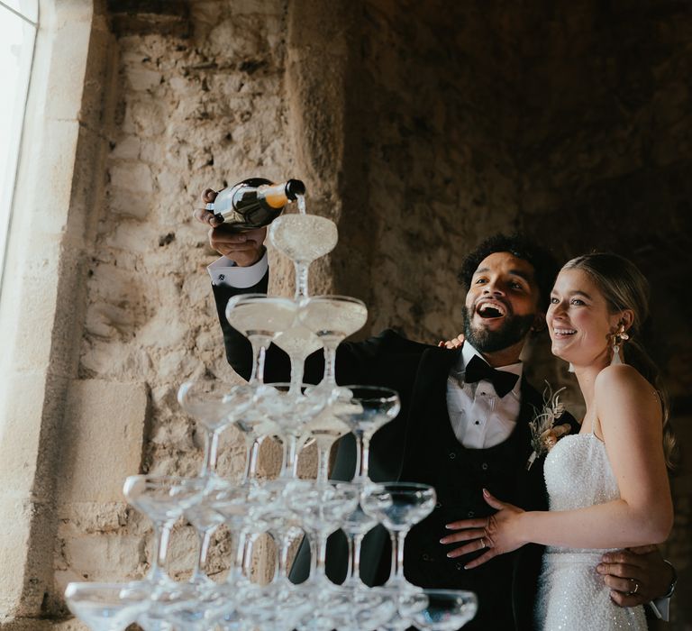 Groom pouring into a champagne tower 