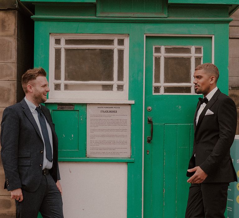 Groom in a tuxedo standing outside a South Yorkshire Police box