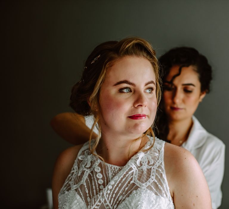 Bride has her dress done up on the morning of her wedding day