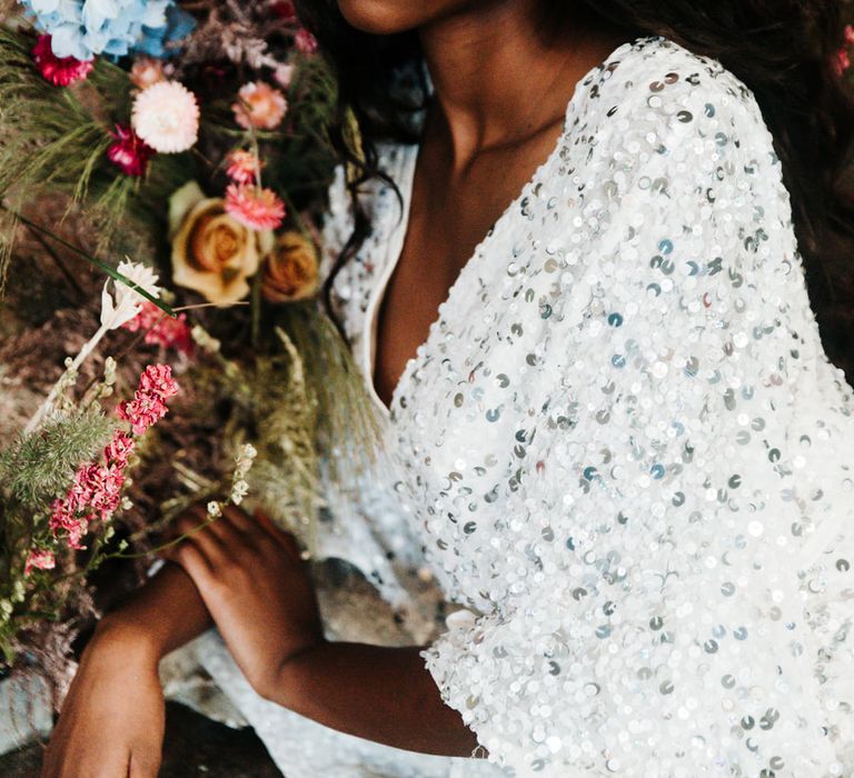 Black bride in a sparkling silver wedding dress and crown with shimmering pink cream eyeshadow and lipgloss