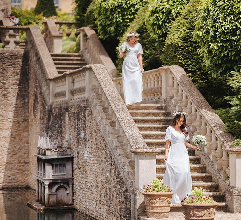 Bridesmaids walk down stone staircase outdoors on wedding day