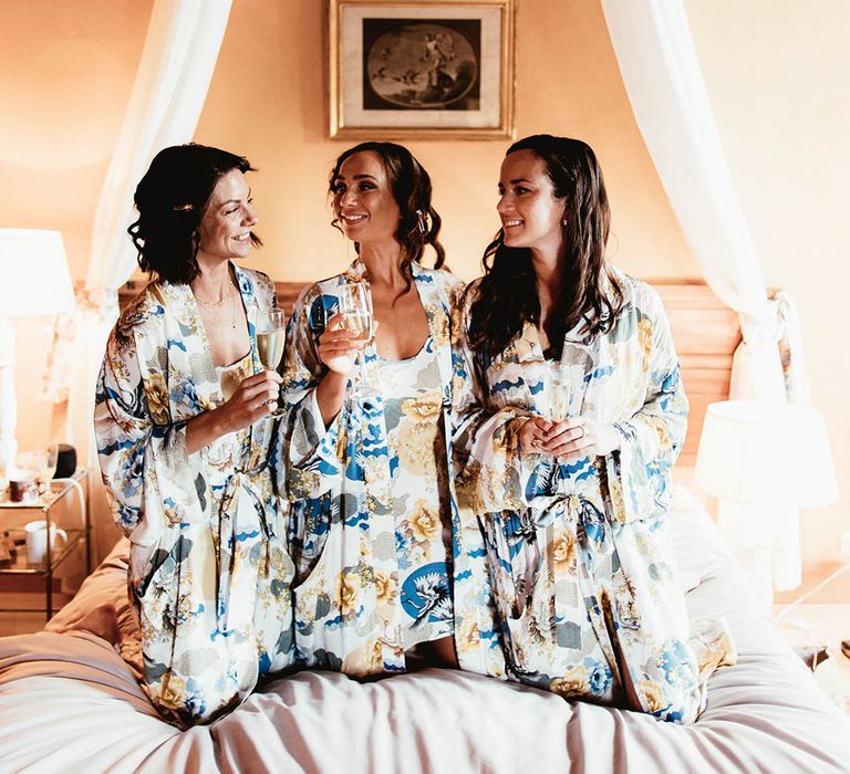 Bride sits with her bridesmaids on the morning of her wedding day wearing matching floral pyjama set