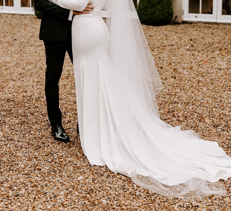 Black-Tie wedding at Northbrook Park with groom in a tuxedo and bride in a fitted wedding dress with cathedral length veil 