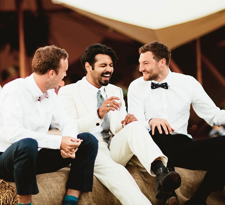 Groom laughs with his groomsmen outdoors