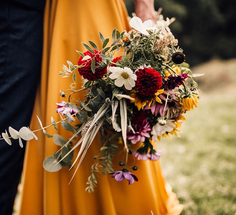 Bride holds colourful floral bouquet