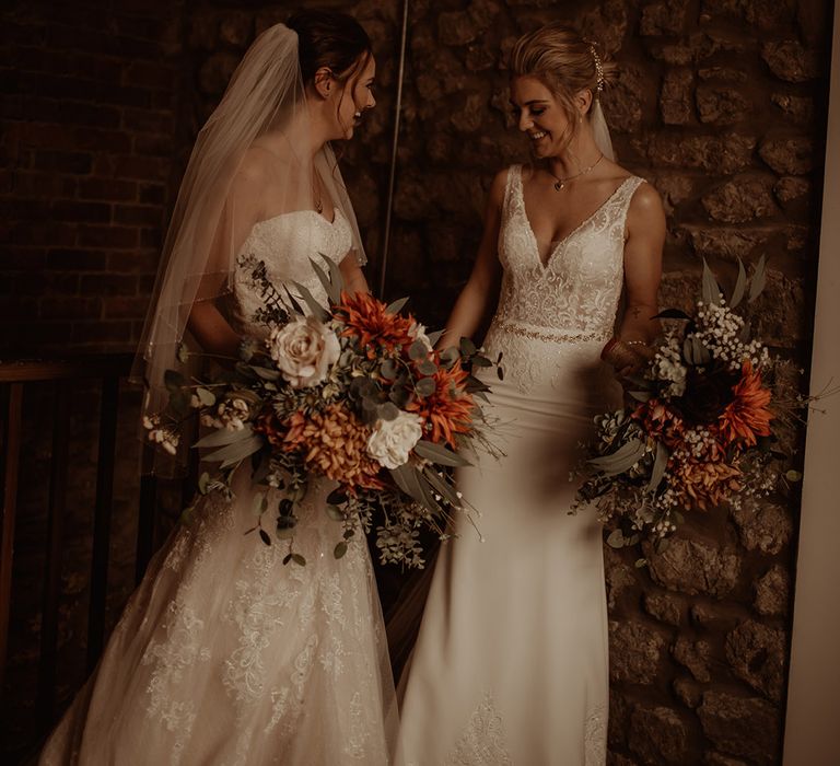 Brides holds large floral bouquet complete with Autumnal colours