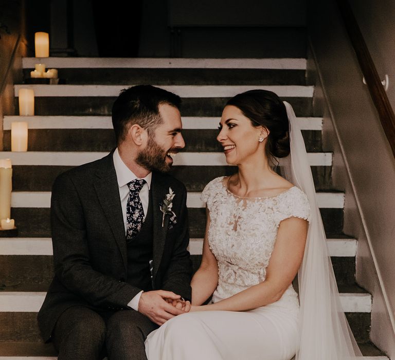 Bride & groom look lovingly at one another on staircase 