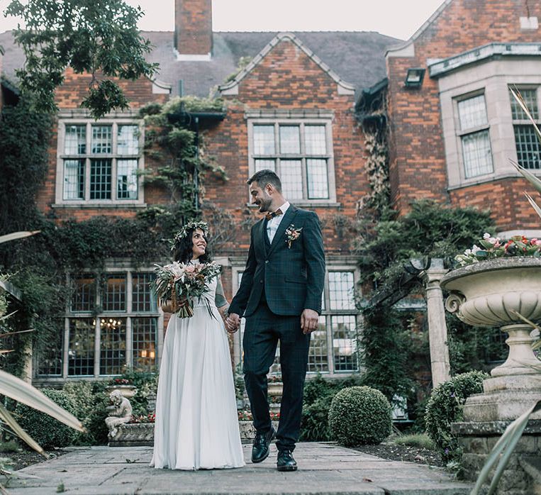 Bride & groom stand in front of Moxhull Hall wedding venue 