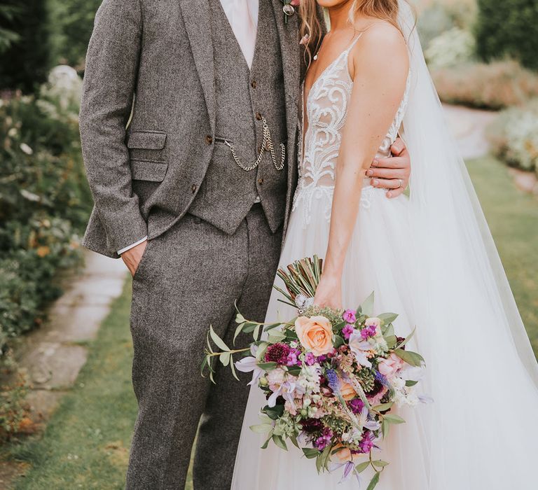 Bride and groom smile together at outdoor country house wedding venue