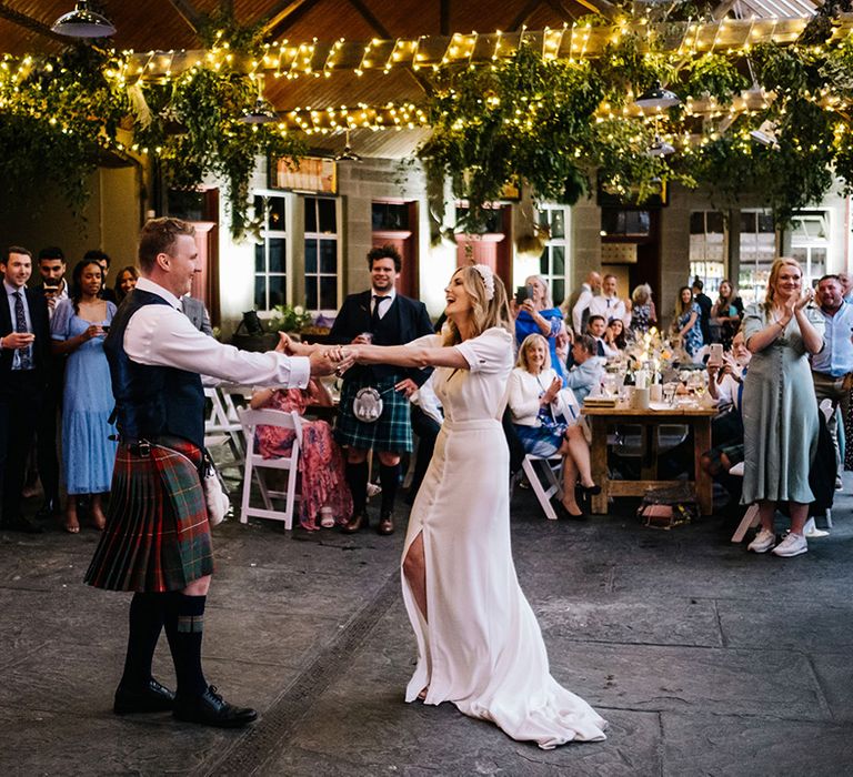 Bride and groom have their first dance together under fairy lights at Errol Park wedding venue 