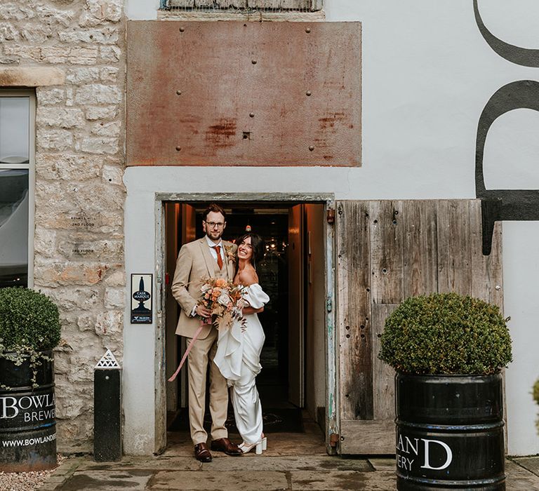 Bride and groom pose together at their industrial wedding venue, Holmes Mill