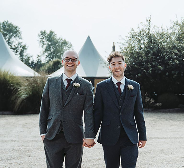 Grooms in grey and dark blue three piece suits with paper rose buttonholes made from pages of their favourite books