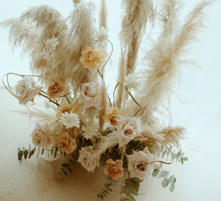 Dried grass with toffee and rust roses flower arrangement for boho barn wedding