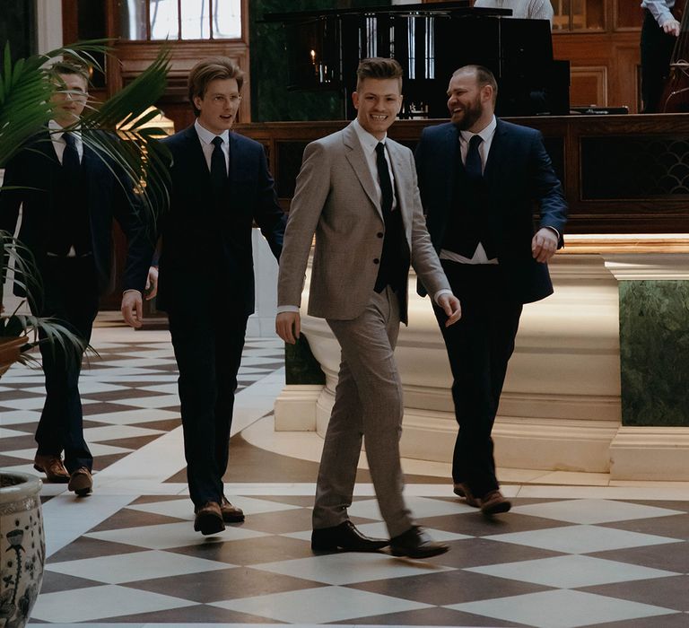 Groom in puppytooth suit from Reiss with groomsmen in navy blue suits and ties 