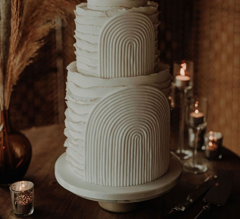 Three tier white ruffle textured wedding cake with rainbow pattern 