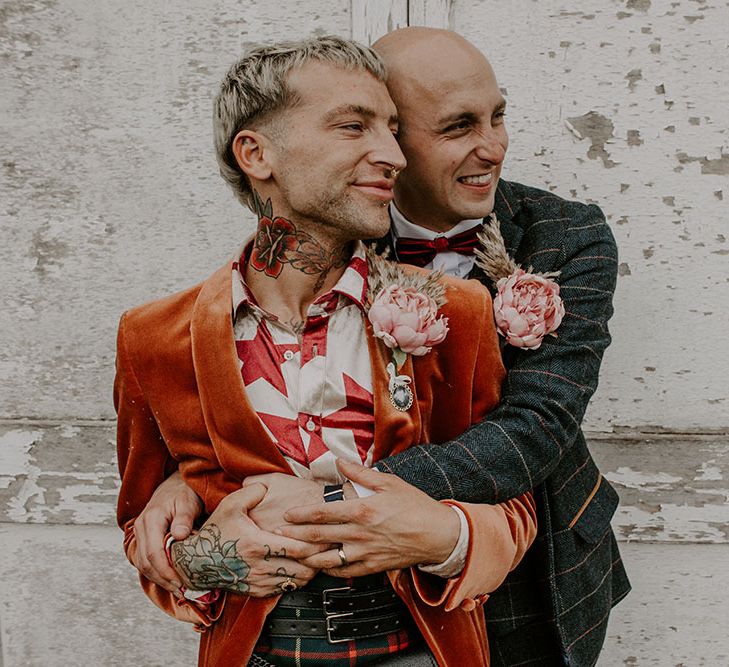 Groom wears orange blazer complete with homemade floral buttonholes 