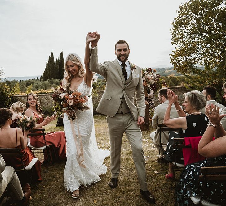 Bride & groom raise their hands in the air after wedding ceremony at the Villa Catignano in Tuscany 