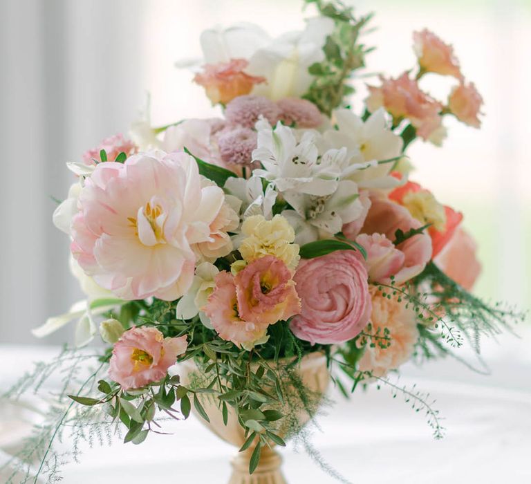 Pastel pink, yellow and white wedding flower arrangements for the wedding tables 